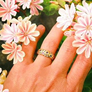 A painstakingly detailed 18K yellow gold dome ring, bedecked with colorful sapphires and shimmering diamonds.